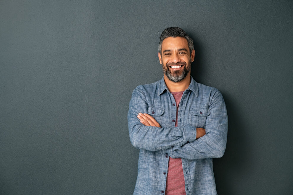 adult man with beard and crossed arms looking at camera