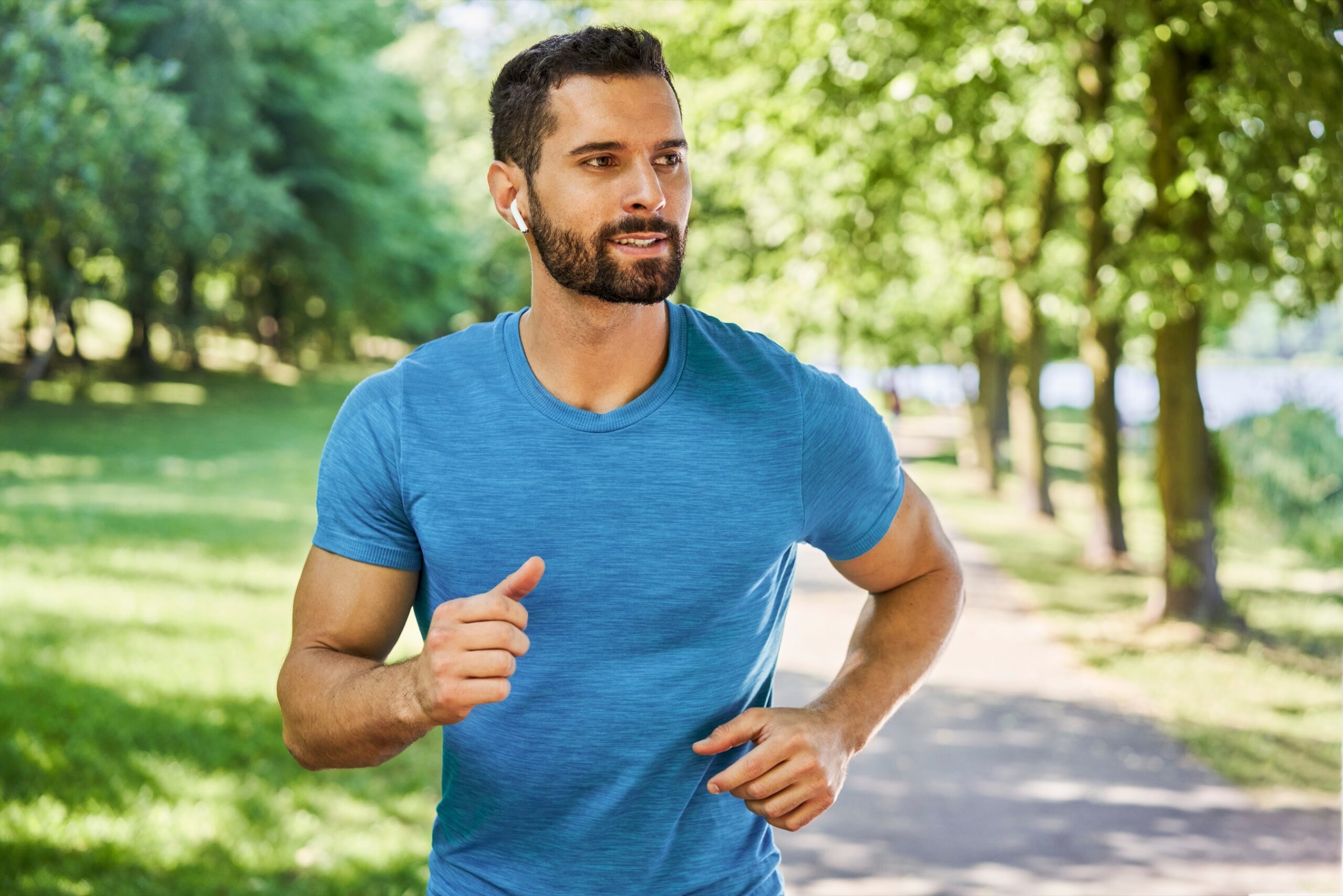 Young man running in park during spring summer